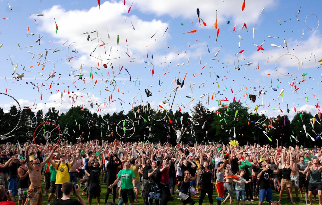 A lively crowd enjoying a colorful juggling event outdoors. Perfect for summer festival themes.