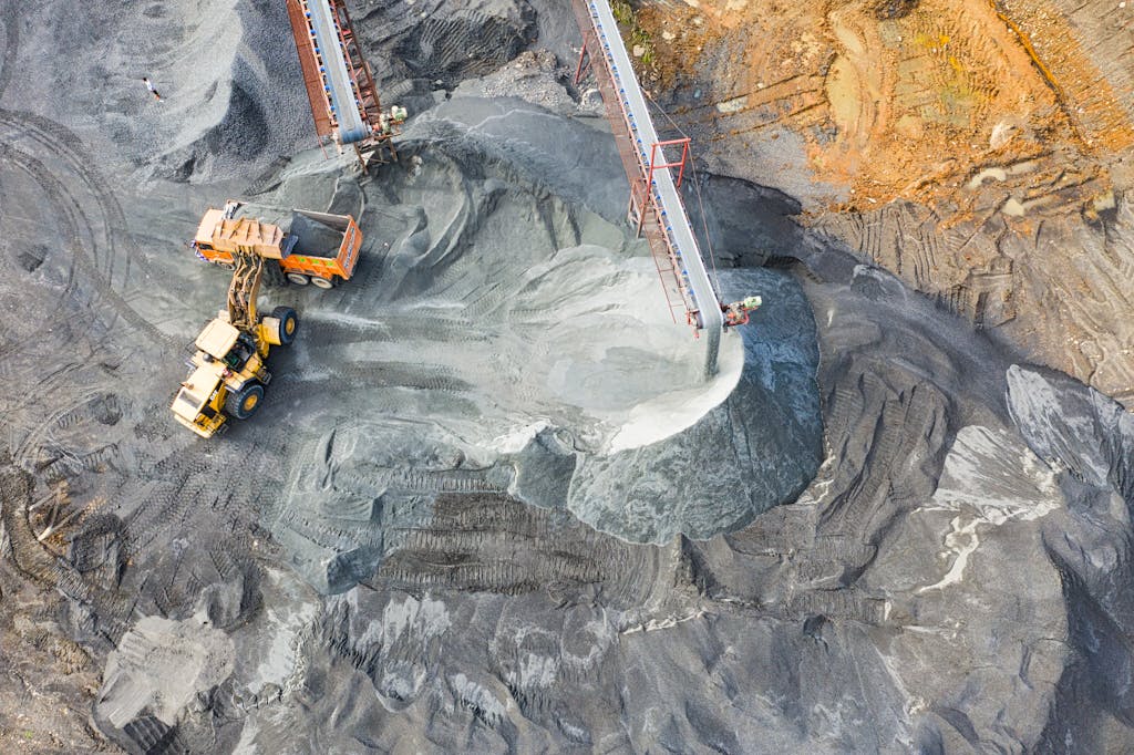 A top-down view showcasing mining operations with excavators and conveyor belts.