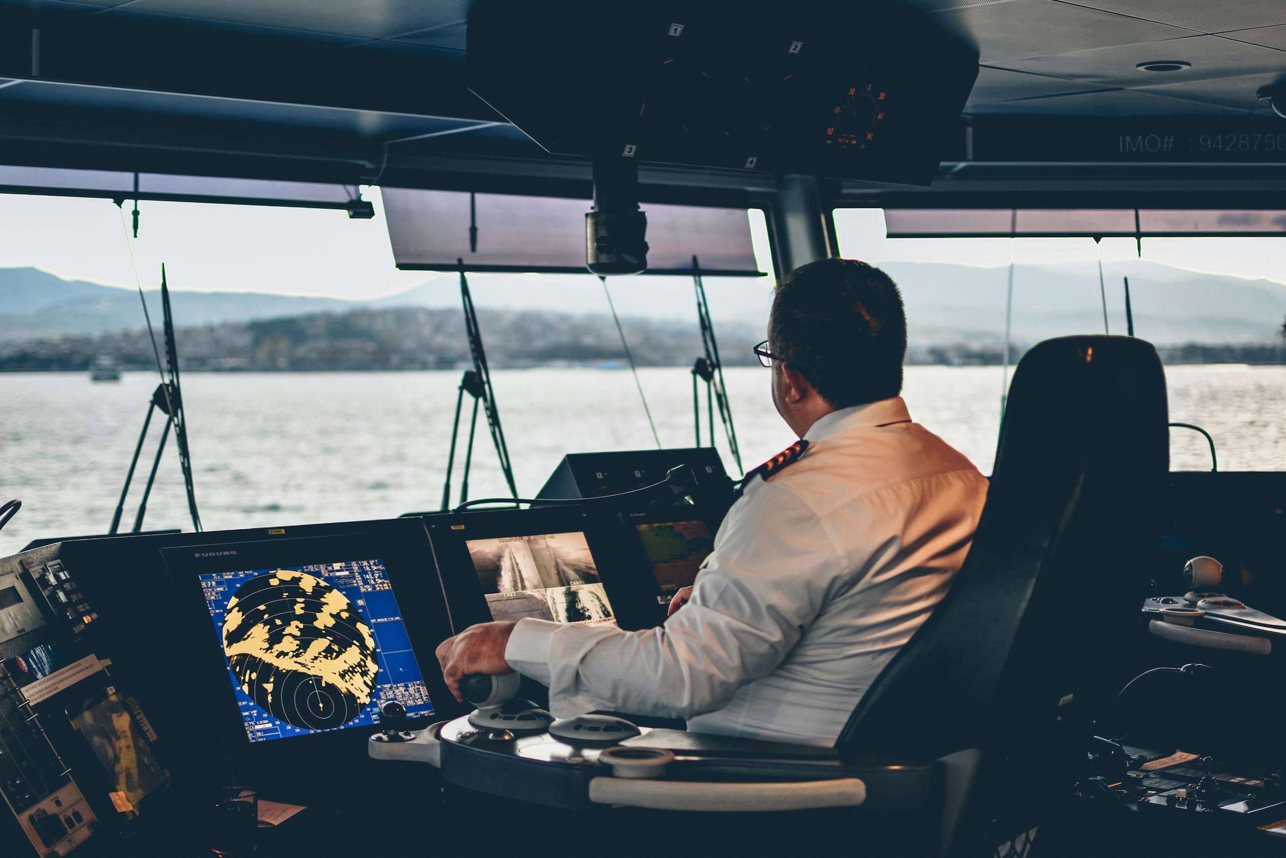 Ship captain operates navigation systems overlooking Istanbul waters. Maritime expertise at its finest.