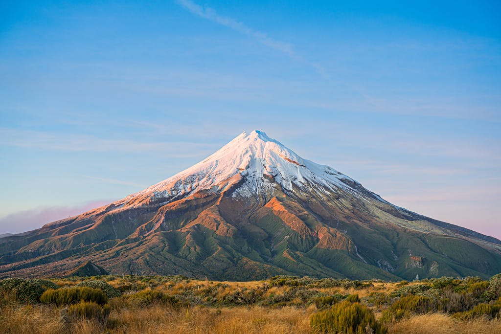 Majestic view of snowcapped Mount Taranaki at sunrise in Taranaki, New Zealand.