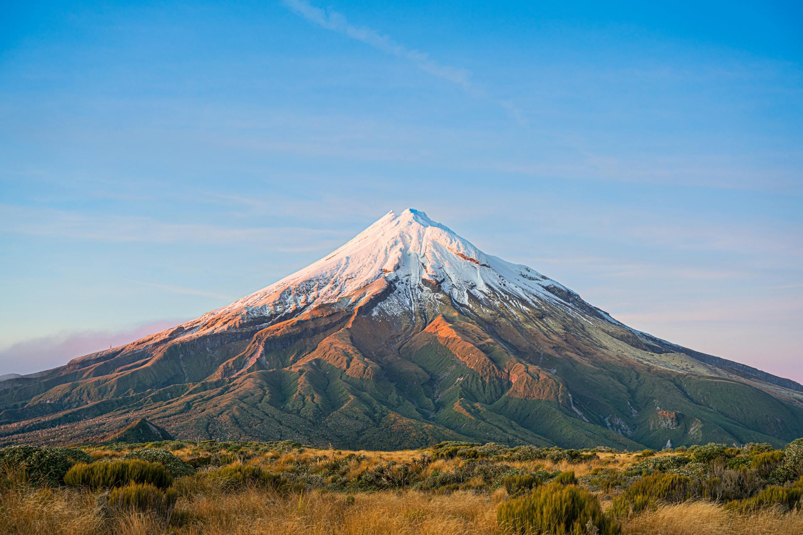 Majestic view of snowcapped Mount Taranaki at sunrise in Taranaki, New Zealand.